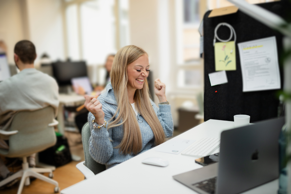 Frau am Computer die sich jubelnd freut.