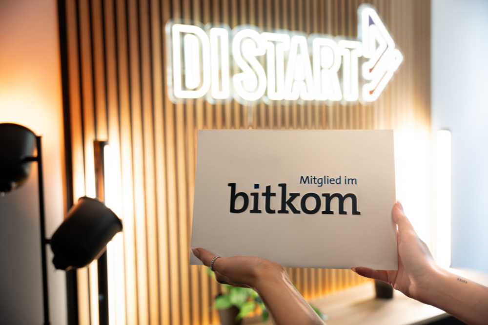 Eine Person hält den Bitkom-Award in die Kamera.