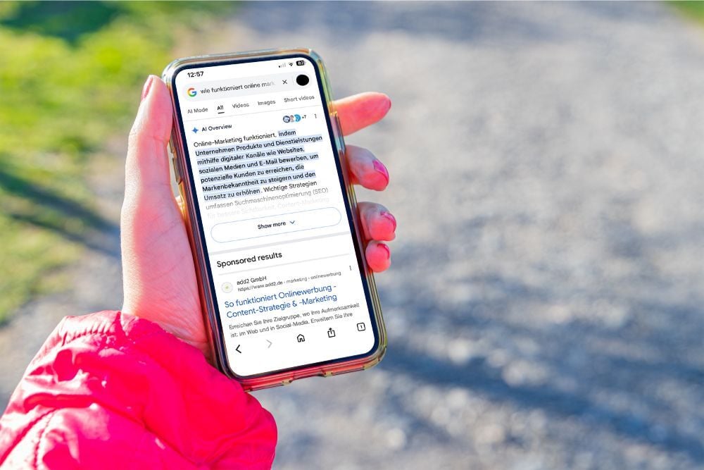 Eine Hand hält rin iPhone mit einem Google AI Ergebnis auf eine Frage die gegoogelt wurde