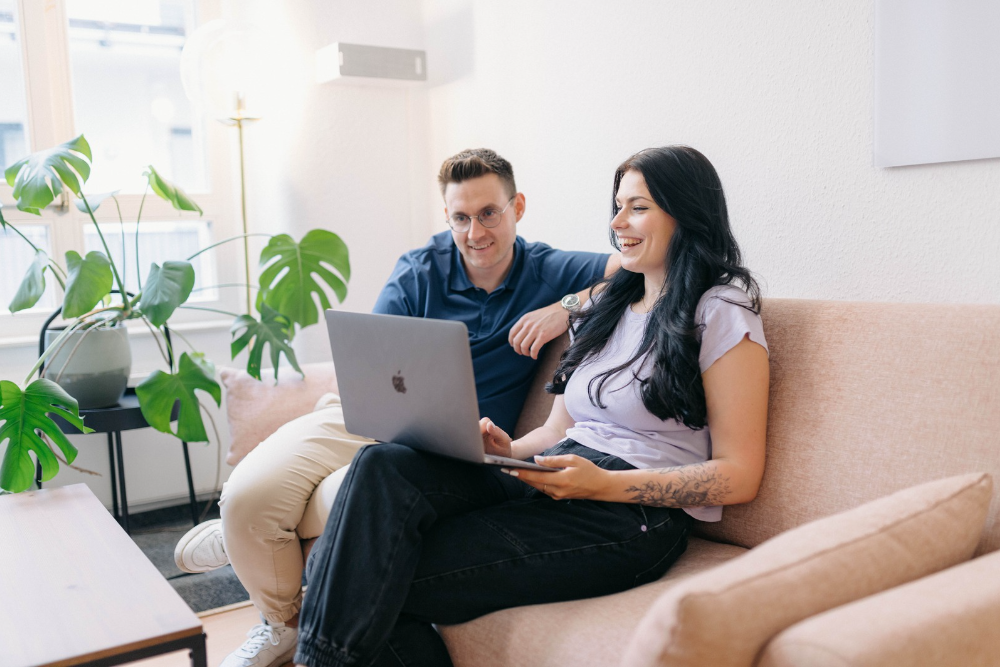 Zwei Personen die zusammen am Laptop arbeiten