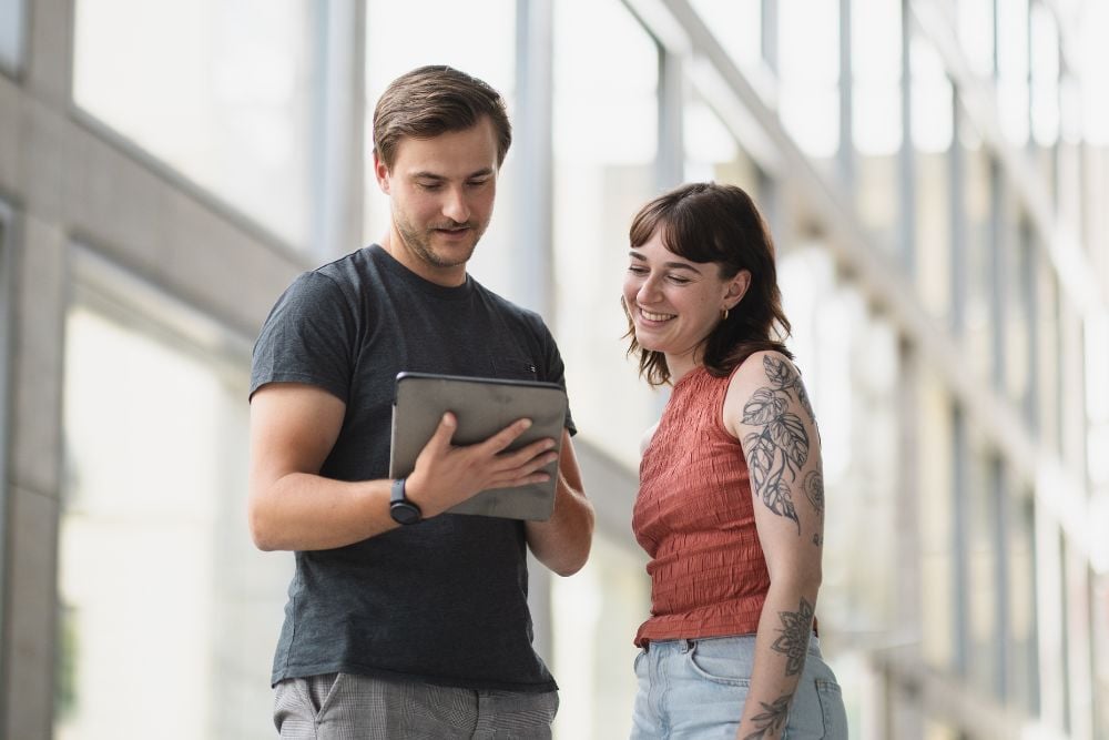 Zwei Personen die gemeinsam am Tablet brainstormen